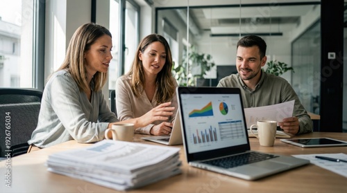 Team discussing business data on laptop in modern office