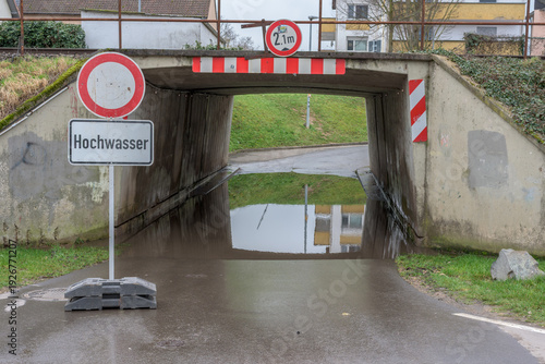 Photos Flooded underpass with high water warning sign and reflection