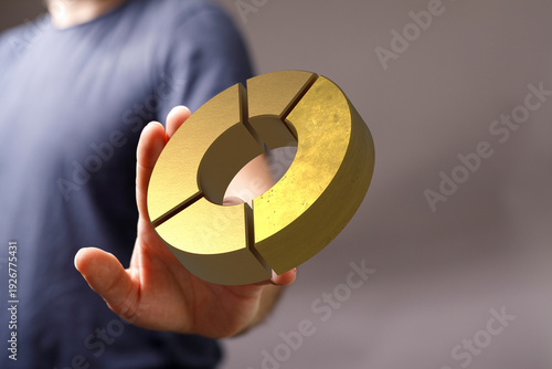 A man's hand presents a gol...