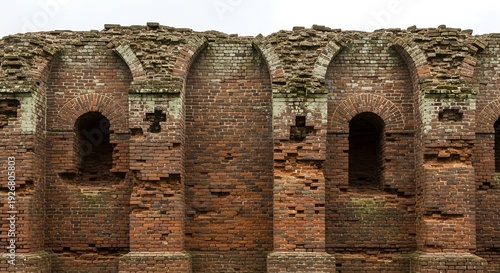 Ancient brick wall with arched openings shows signs of decay and history.