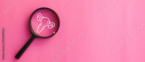 close up top view on magnify with uterus symbol on pink background represent about women health checkup and lifestyle for health and wellness concept
