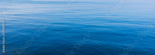 Tableau sur toile Blue water surface with gentle ripples and soft light reflection,An abstract top-down view of calm blue water surface