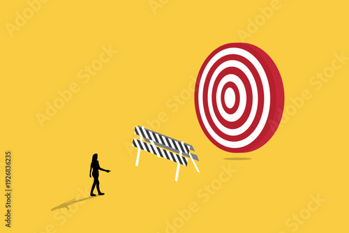Business woman walking toward a giant target behind a road barrier, representing goal setting, overcoming obstacles, and professional performance success