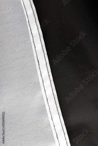 Seams on nylon fabric with stitches. Synthetic fabric texture. Macro detail.