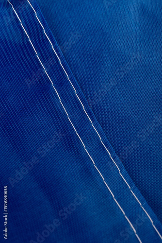 Seams on nylon fabric with stitches. Synthetic fabric texture. Macro detail.