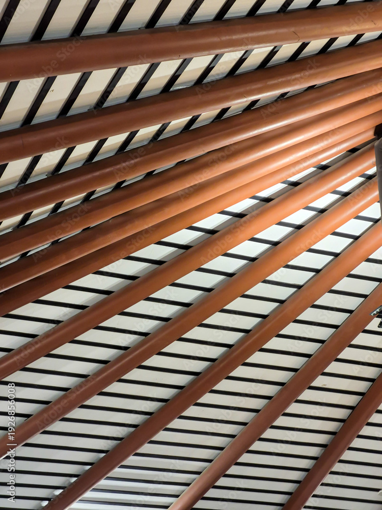 Obraz premium abstract architectural detail of modern ceiling with brown pipes and Parallels line patterns. background