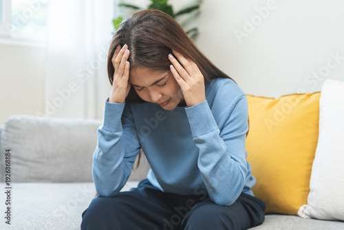 Bild auf Leinwand Depressed anxiety asian young woman frustrated hand on head, touching her temples, suffering stressed, sick, tired, crisis on sofa from headache, migraine pain tension problem health care concept
