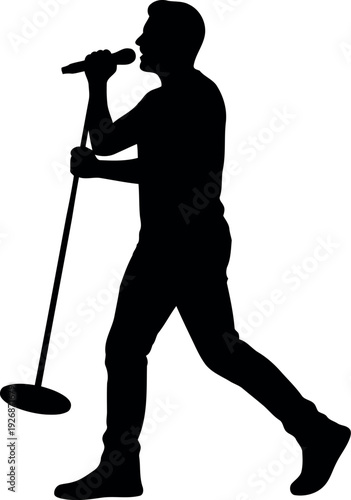 Silhouette of male singer performing with microphone and stand on stage