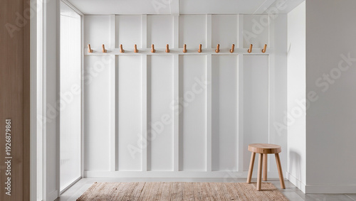 A clean interior with a white board and batten wall a row of ten wooden hooks a round wooden stool and a textured rug