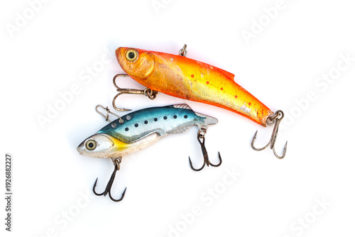 Pair of weathered vintage fishing lures with scratches and rusty treble hooks isolated on white background. Angling equipment showing signs of heavy use and weathering from successful fishing trips.