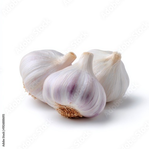 Three garlic bulbs grouped on white studio surface arrangement