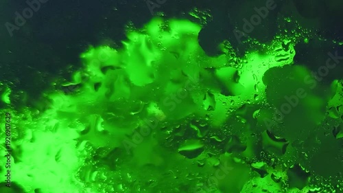 Close-up of vibrant green liquid splashing in water with a dark background and shallow depth of field.