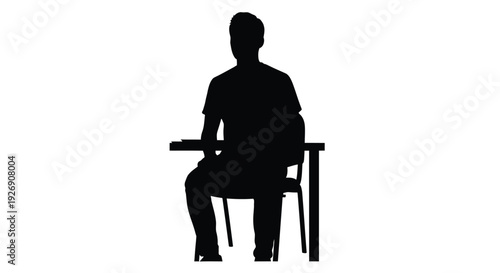 A person seated at a desk captured in a dark silhouette