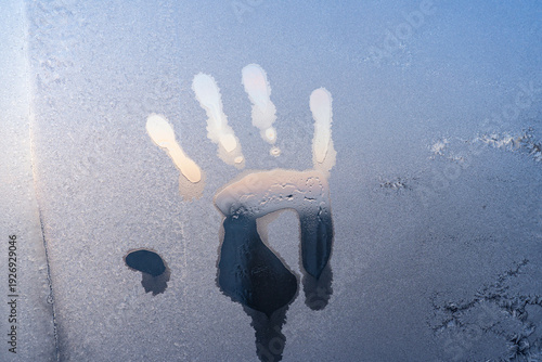 Valokuva A handprint on a frozen winter window