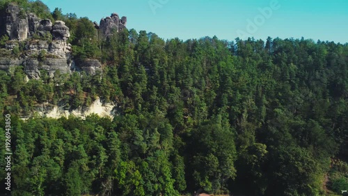 Spiral-rising aerial shot of the giant boulders atop the mountain in the Amselgrund valley, located in the Saxon Switzerland National Park, Germany