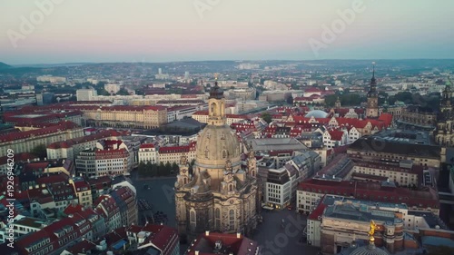 A pushing forward and circular aerial shoot of the Frauenkirche with Dresden's Old Town  behind in Dresden in Germany at dawn