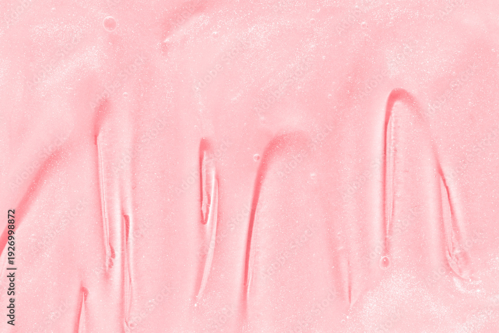 Fototapeta premium Smooth pink cosmetic cream texture with shimmering surface for skincare and beauty products.