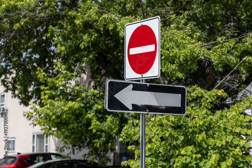 Do not enter and one way traffic signs on the street. Red circle prohibited entry sign with arrow