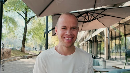 A middle-aged man with short hair smiles warmly at the camera. Perfect 4K video for lifestyle, portrait, and positive emotions content.