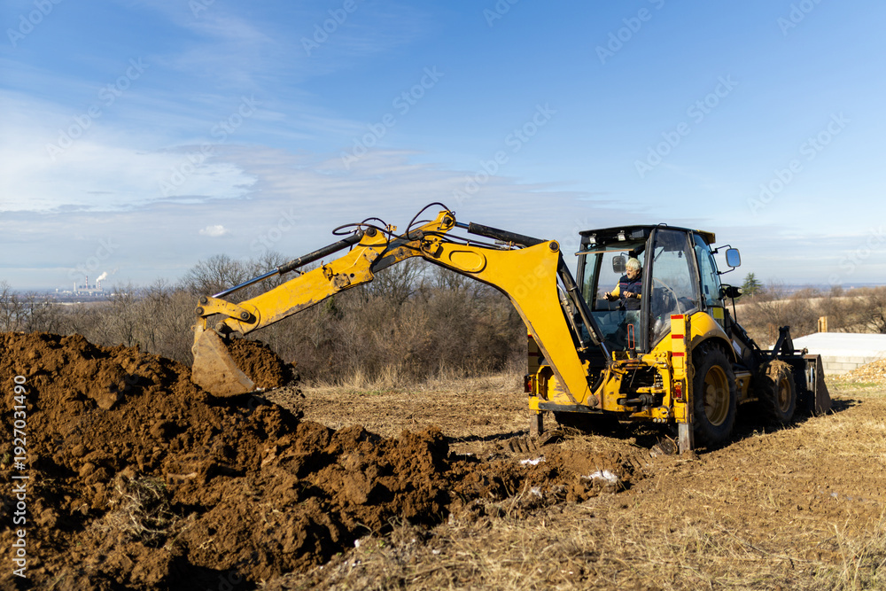 Obraz premium Backhoe loader performing earthmoving works outdoors