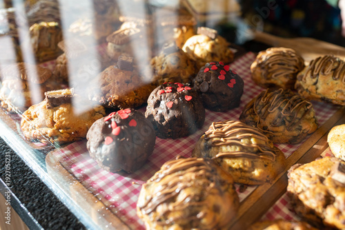Assorted cookies with chocolate and heart sprinkles displaying in bakery case