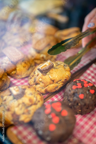 Hand using tongs picking fresh baked cookie