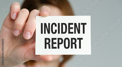 Person holding a card with INCIDENT REPORT text for workplace safety, legal documentation, and risk management concept.