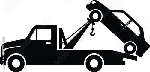 Tow truck hauling a car on a city street during a recovery operation