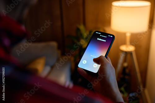 Wallpaper Mural Close-up of hand holding smartphone showing unknown incoming call in living room. Concept of spam call, telemarketing, scam risk and mobile communication Torontodigital.ca