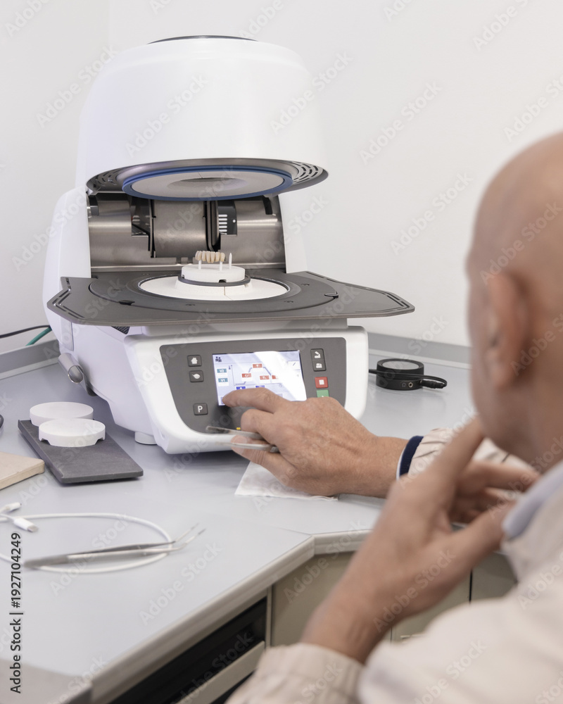 Obraz premium Orthodont programs dental ceramic oven for baking enamel of tooth implants. Dental prosthetics