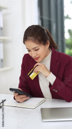Business woman shopping online, working in a modern office, an office employee using cell phone for shopping on application, holding a credit card