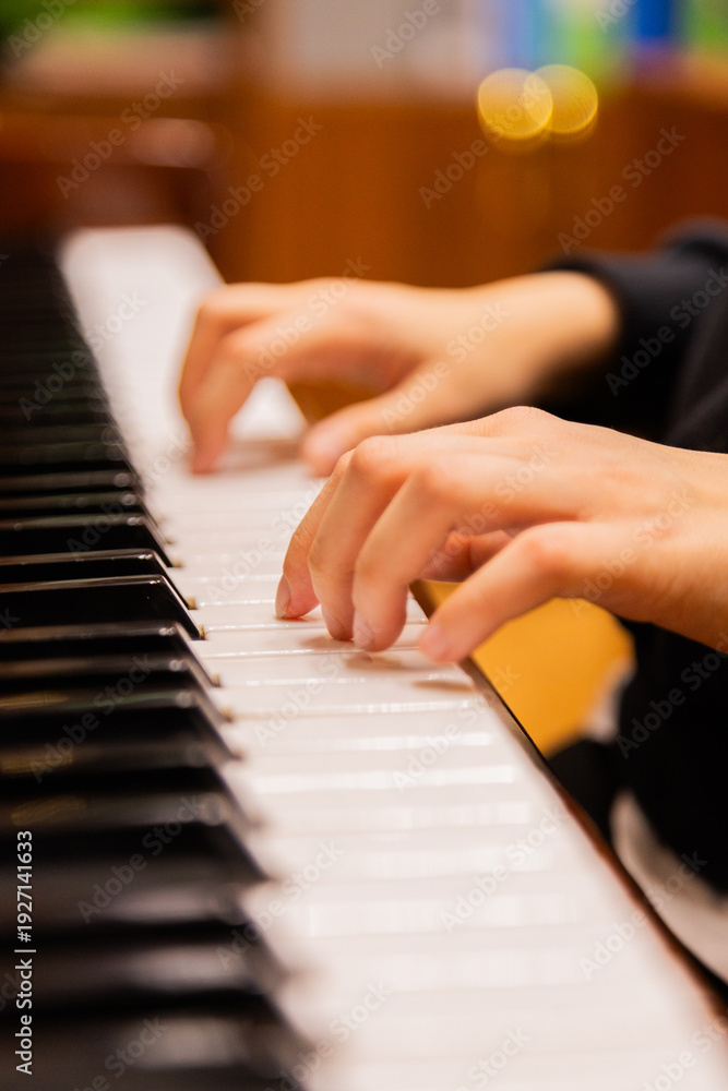 Fototapeta premium Close-up of a music performer's hand playing the piano. selective focus