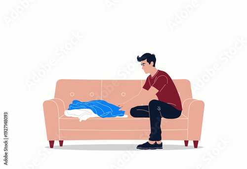 Man folding clothes on a beige sofa while sitting in a relaxed manner, wearing casual attire, in a minimalist living space with a focus on simplicity and comfort