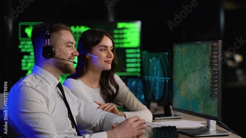 Air traffic controllers monitoring flight paths in a dark control center