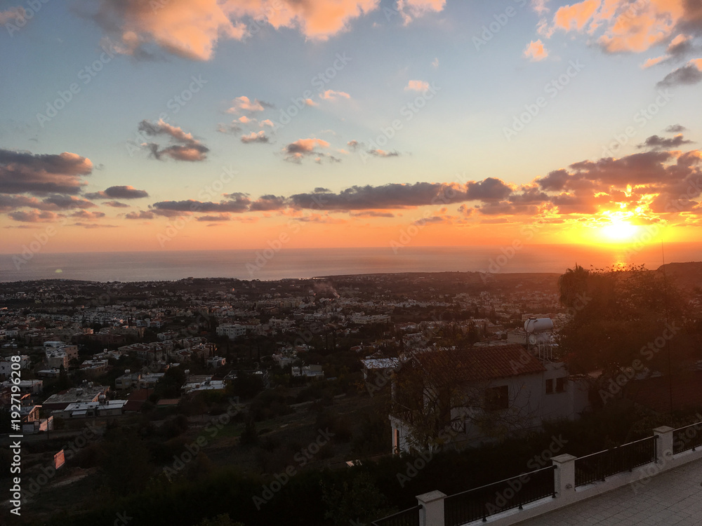 Fototapeta premium Sunset over coastal town with sea horizon in Cyprus. Evening atmosphere, travel inspiration and urban landscape panorama concept