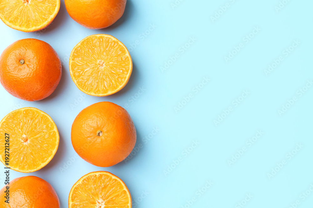 Fototapeta premium Fresh ripe tangerines on light blue background, flat lay. Space for text
