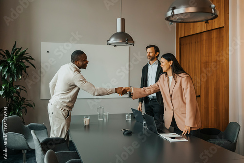Smiling businesswoman congratulating candidate after interview in meeting room
