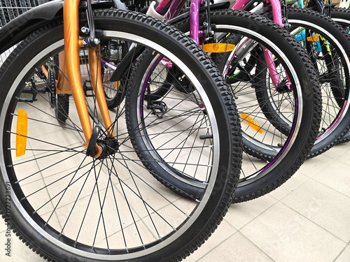 A bike shop displays rows of new bicycles. A close-up of the wheels.