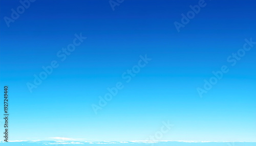 A vast expanse of clear blue sky stretches across the frame, transitioning smoothly 