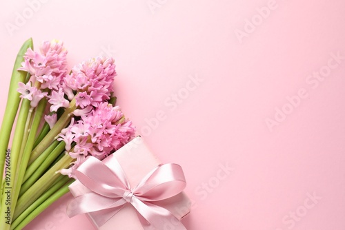 Beautiful hyacinth flowers and gift box on pink background, flat lay. Space for text
