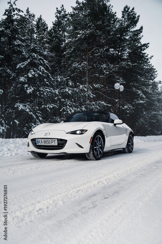 Φωτογραφία White roadster Mazda MX-5 Miata in the winter forest