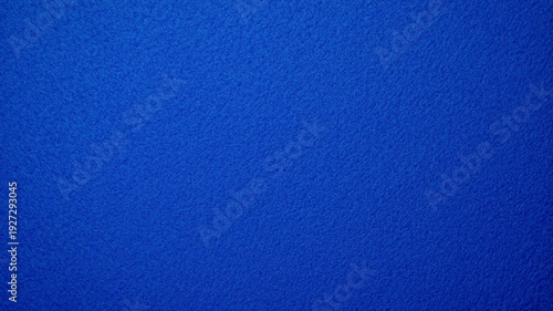 Uniform dark cerulean blue fabric texture background. Fine tight-knit grain similar to felt or heavy cardstock, soft matte finish with very subtle vertical light gradient, clean minimalist blue, luxur