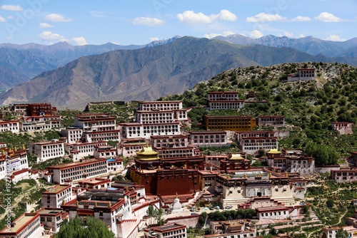 Panoramic view of Ganden Monastery on a mountain ridge near Lhasa, Tibet, showcasing Tibetan Buddhist architecture, dramatic highland scenery, cultural heritage, and sacred landscapes.