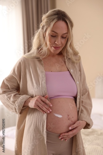Free Download Pregnant woman applying cream on her belly at home - GFXLoad