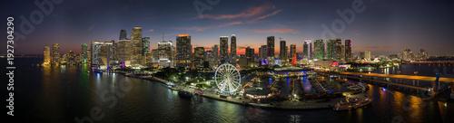 American urban landscape at night. Miami marina and Skyviews Observation Wheel at Bayside Marketplace with reflections in Biscayne Bay water and skyscrapers of Brickell, city's financial center