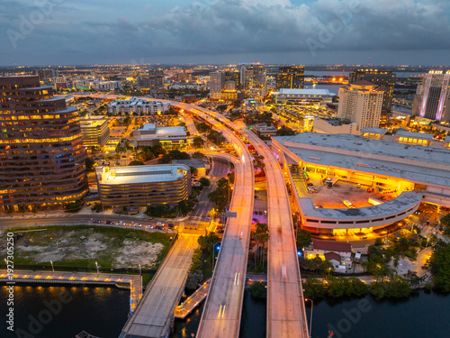 Downtown district of Tampa city in Florida, USA after sunset. Brightly illuminated highway bridge and high buildings in modern American urban area.