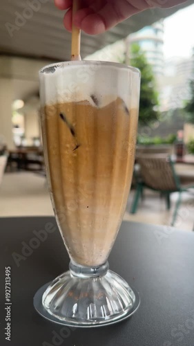 Closeup of Stirring a Delicious Iced Cappucinno Coffee Drink