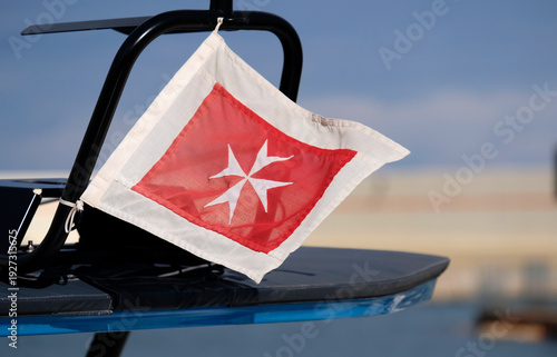 фотографія The Maltese red merchant flag with a white Maltese cross