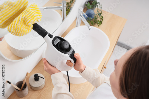 Woman steam cleaning mirror...