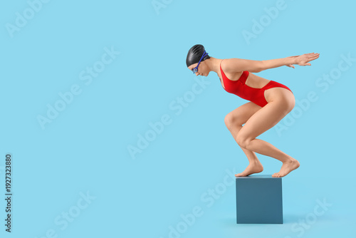 Young female swimmer on blu...